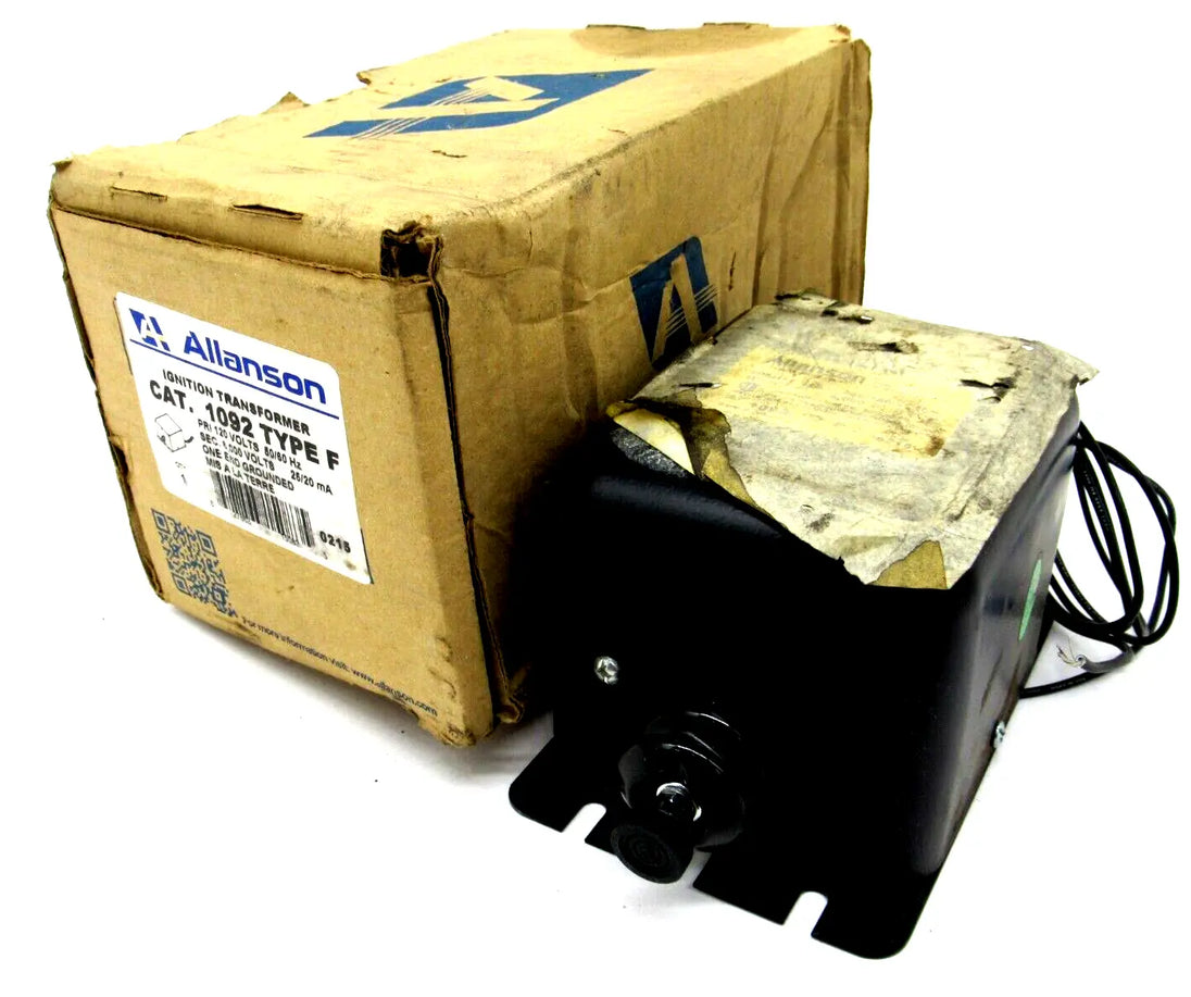 El transformador de encendido ferromagnético Allanson 1092 type f, negro, con etiqueta superior y soportes de montaje, está junto a una caja de cartón marrón gastada con etiqueta y código de barras.