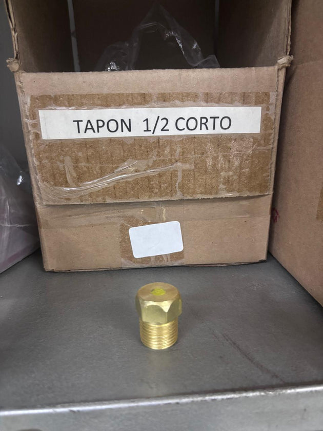 Tapón corto de 1/2 con cabeza hexagonal y rosca exterior junto a etiqueta
